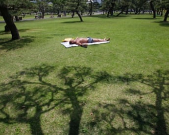 And relax: a man takes a nap in a park on a warm day in Tokyo.