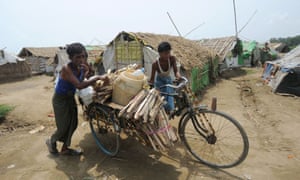 Muslim Rohingya men arrive back at a camp for internally displaced people in the village of Mansi on the outskirts of Sittwe, Burma with their belongings on a tricycle after a killer cyclone wrecked thousands of homes.