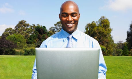 Businessman holding laptop in field