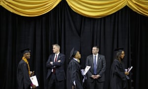 U.S. Secret Service agents keep watch as graduates of Bowie State University arrive for the school's graduation ceremony at the Comcast Centre on the campus of the University of Maryland in College Park, Maryland. First lady Michelle Obama delivered the commencement speech for the 600 graduates of Maryland's oldest black university and one of the ten oldest in the country.