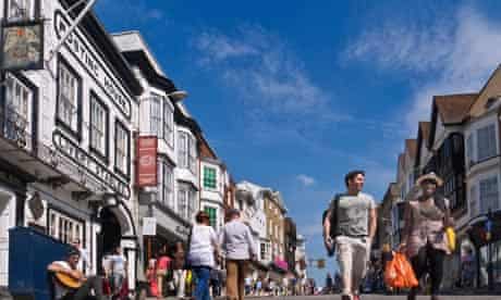 Shoppers in Guildford historic cobbled High Street enjoying the sunshine Guildford Surrey UK