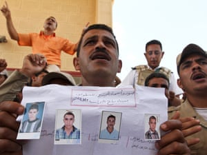 An Egyptian border policeman displays pictures of four of their colleagues who were kidnapped last Thursday, during a protest at the closed Rafah border crossing between Egypt and the Gaza strip, in Rafah, Egypt. Security officials said 17 military and more than 20 police armoured vehicles were deployed in northern Sinai Monday as a response to the kidnapping.