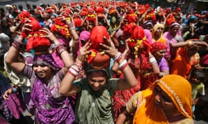 Hindu women carry Kalash, earthen pots containing sacred water with a coconut on top, during a religious procession known locally as Ganga Kalash Yatra in the western Indian city of Ahmedabad.