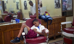 Hurry up Dad. Jose Luis, 7, in his school uniform, falls asleep in a barber's chair, while waiting for his father's work shift to end, in Old Havana, Cuba.