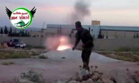 This image from amateur video obtained by a group which calls itself Ugarit News, which AP says is consistent with its reporting, shows a rebel fighter firing a mortar with the help of a drawstring in Aleppo, Syria, on 28 May 2013.