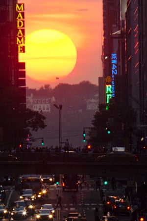 People take pictures of sunset on 42nd Street in New York during the biannual occurrence named 'Manhattanhenge' last night. Manhattanhenge, coined by astrophysicist Neil deGrasse Tyson, occurs when the setting sun aligns itself with the east-west grid of streets in Manhattan, allowing the sun to shine down all the streets at the same time.