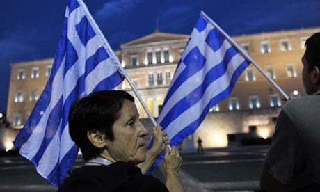Anti-austerity protesters hold Greek flags in front of parliament in Athens last year