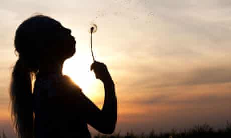 Silhouette of a girl blowing dandelion 