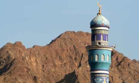 A minaret cast against the mountains in Oman