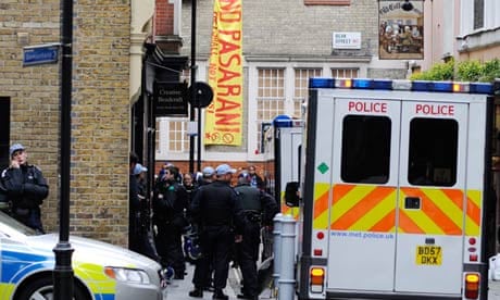 Riot police officers surround a building in Beak Street