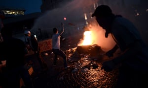 Protesters clash with riot police at Taksim square as darkness falls.