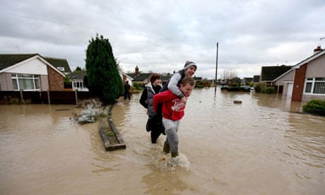 Residents of St. Asaph, Denbighshire, North Wales make their way through flood waters