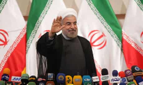 Iran's president-elect, Hassan Rouhani, waves during his first press conference