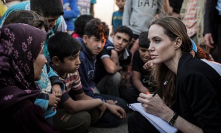 Angelina Jolie listening to Syrian refugees in a Jordanian military camp based the the Jordan-Syria border.