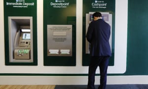 Britain's Chancellor of the Exchequer George Osborne uses a cash machine at a brank of Lloyds TSB bank in central London