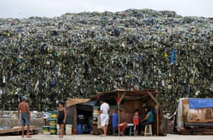 Residents are pictured near a dump site in Manila in the Philippines. As part of escalating efforts across the nation's capital to curb rubbish that exacerbates deadly flooding, the financial capital has banned disposable plastic shopping bags and styrofoam food containers.
