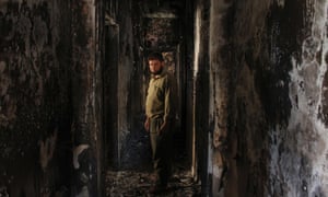 A Free Syrian Army fighter stands inside a burnt house in the Seif El Dawla neighbourhood in Aleppo on 23 June 2013.