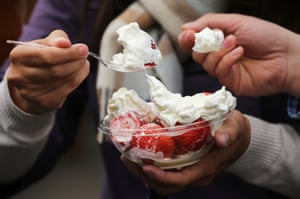Spectators enjoy a bowl of strawberries and cream on day one of the Wimbledon Lawn Tennis Championships at the All England Lawn Tennis and Croquet Club in London, England.