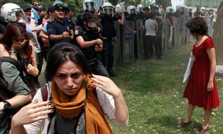 Turkish riot policeman prepares to use tear gas against woman 1