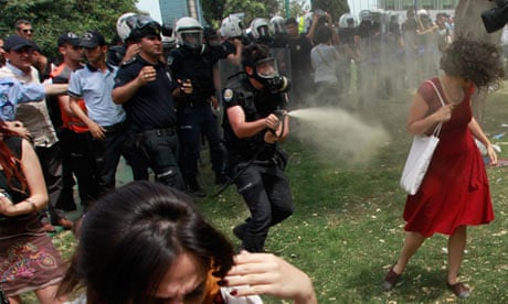 Turkish riot policeman uses tear gas against woman