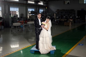 Love on the assembly line: Hongbin Li and his wife Lijun Du, both from Nanchong, Sichuan pose for a ph