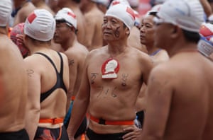 A man wearing a badge of China's late Chairman Mao Zedong takes part in an event to swim across the Yangtze River in Wuhan, China. Mao, a widely-known swimming fan, was reported to have his last swim in the Yangtze on the same day 47 years ago. The Chinese characters on the man's chest read, 'Long Live'.