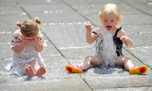 Luella Facer and her friend Summer Passmore, both two, cool off in the pavement fountains at the Royal Academy court yard in central London, as the hot weather continues to cover the UK.
