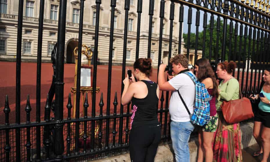 Tourists take pictures of the easel announcing the royal birth.