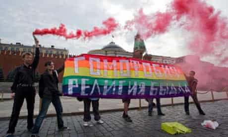Gay rights activists hold a banner saying "Homophobia - the religion of bullies" Red Square, Moscow