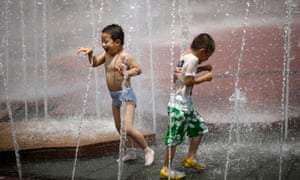 Boys cool off in a fountain at a park in Shanghai, China with hot weathe rising up to 40 degrees Celsius.