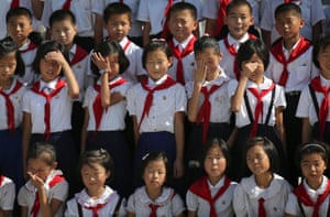 North Korean schoolchildren rub their eyes after having to face into the sun while getting their class photograph taken. The children are on a tour of the park surrounding Kumsusan Palace of the Sun, the mausoleum where bodies of the late leaders Kim Il Sung and Kim Jong Il lie embalmed in Pyongyang.