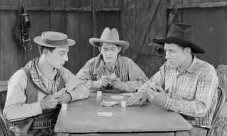 Buster Keaton playing cards with two cowboys in a scene from Go West