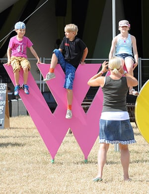 Womad: Children pose for a photograph on a WOMAD sculpture