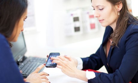 Shop assistant helping a customer choosing a smartphone