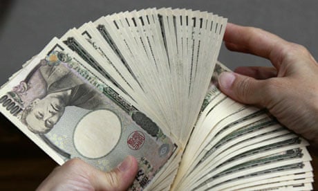 A bank teller counts 10,000 yen (118 USD