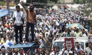 Supporters hold portraits of the overthrown President Morsi at a tent camp near Rabia Al Adawiyya mosque in Cairo, Egypt.