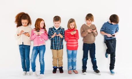 Children using smartphones, standing in a row