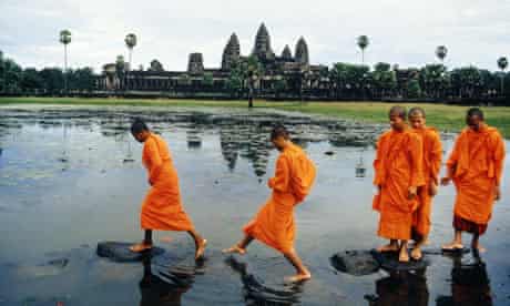 Buddhist Monks Crossing Lake on Rocks
