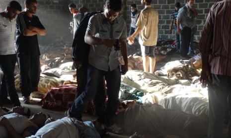 A handout image released by the Syrian opposition's Shaam News Network shows people inspecting bodies of children and adults laying on the ground as Syrian rebels claim they were killed in a toxic gas attack by pro-government forces in eastern Ghouta, on the outskirts of Damascus on 21 August, 2013.