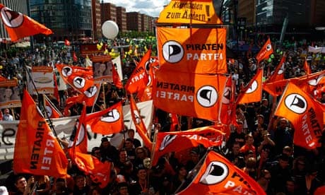 Supporters of German wing of Pirate Party wave their flags during rally in Berlin