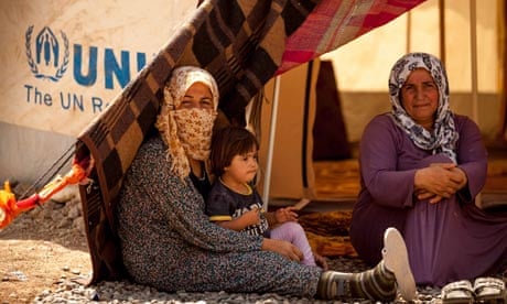 Grandmother and mother with disabled child, exhausted from the long way from Syria to Iraq