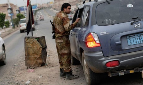 A Yemeni soldier inspects a car at a checkpoint on a street leading to the US embassy in Sana'a