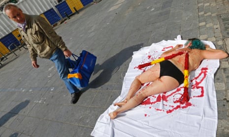 An animal rights protester lies on the pavement covered in fake blood during a demonstration calling for the abolition of bullfights, in central Brussels.