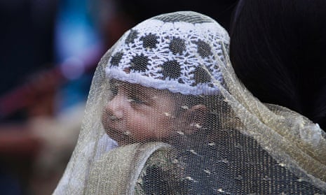 A child is carried by his mother at a market during the Eid al-Fitr festival in Srinagar, India.