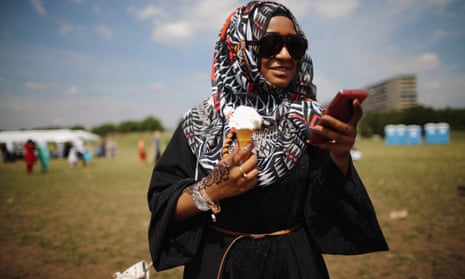 A woman enjoys an ice-cream during an Eid celebration fun fair in Burgess Park in London.