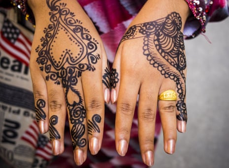 A woman shows her henna tattooed hands after the Eid al-Fitr services at Haroon Mosque in Bangkok.