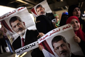 Female supporters of ousted Egyptian President Mohammed Morsi carry posters bearing his portrait druing a demonstration in support of Morsi in Cairo. Islamist supporters of deposed Egyptian president Mohamed Morsi planned new rallies as the interim premier suggested a crackdown on their protest camps was imminent Photograph: Gianluigi Guercia/AFP/Getty Images