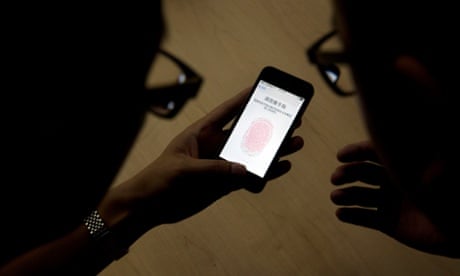 An Apple employee instructs the use of the fingerprint scanner technology built into the iPhone 5S during a media event held in Beijing, China.