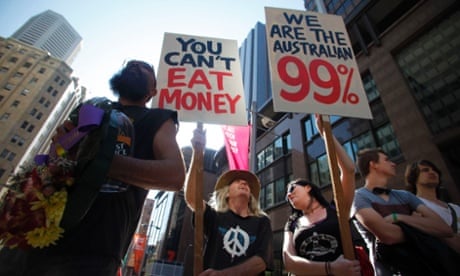 Protesters of the Occupy Sydney movement hold signs in front of the Reserve Bank of Australia in central Sydney October 15, 2011. Protesters worldwide geared up for a cry of rage on Saturday against bankers, financiers and politicians they accuse of ruining global economies and condemning millions to poverty and hardship through greed. REUTERS/Lukas Coch (AUSTRALIA - Tags: CIVIL UNREST POLITICS BUSINESS) :rel:d:bm:GF2E7AF0NKC01