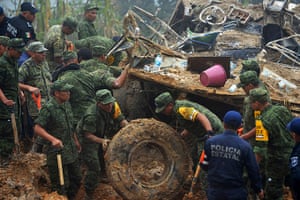 mexico floods: Soldiers and police work around the wreckage of a bus 